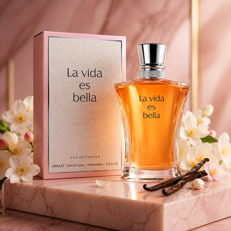 ادکلن La Vida Es Bella روی پایه صورتی با گل‌های سفید و نورپردازی لطیف