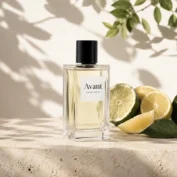 ادکلن Avant Eau De Parfum با بطری شفاف و درپوش مشکی در کنار برش‌های لیمو روی سطح سنگی روشن